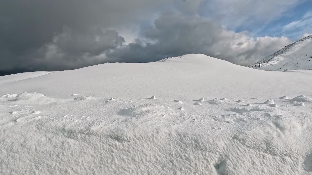 Snowdrifts seen from a moving car along the road.