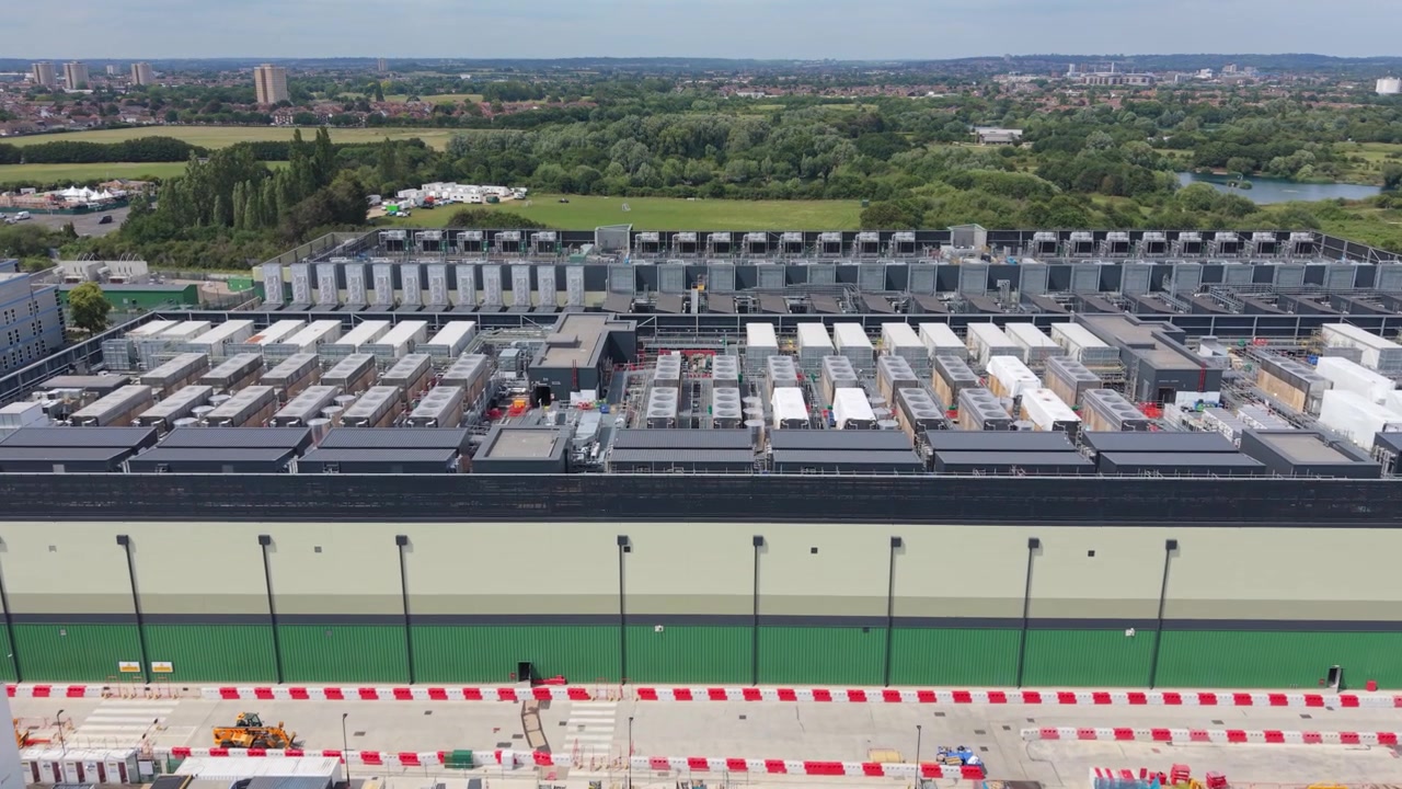 Una prospettiva aerea cattura un vasto complesso di data center, mostrando i suoi edifici operativi e un cantiere adiacente attivo