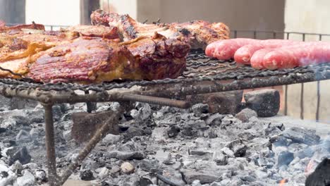 salchichas y carne cocinadas en una parrilla de barbacoa con el calor del carbón ardiente