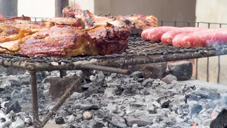 sausages and meat cooking on a barbecue grill with the heat of burning charcoal