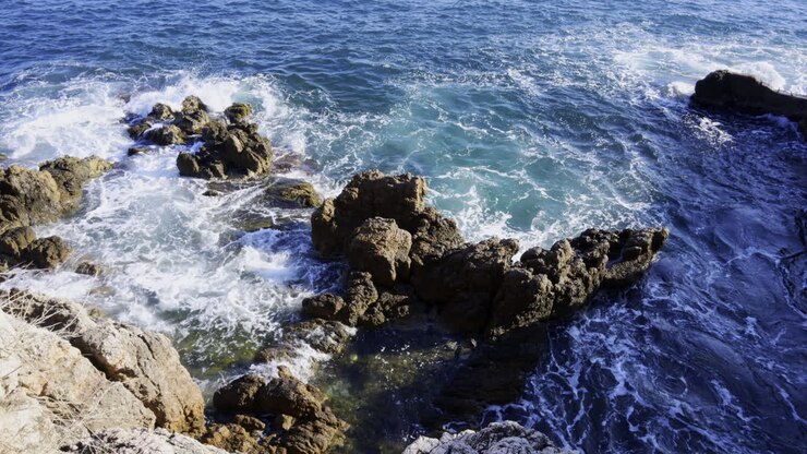 Les vagues de la mer Méditerranée se brisant sur les rochers du rivage de la Côte d’Azur