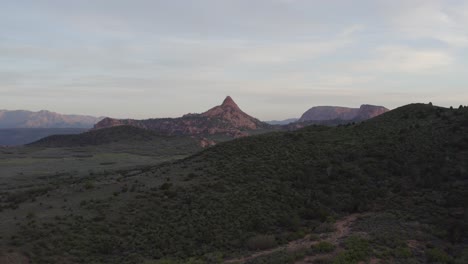 rastreando lentamente sobre una colina para revelar una vista del atardecer del parque nacional zion con grandes acantilados y formaciones rocosas