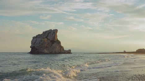 roca en el mar cerca de la costa durante la puesta de sol