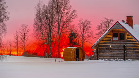 time lapse intense orange, red and yellow sunset with cabin and barrel sauna