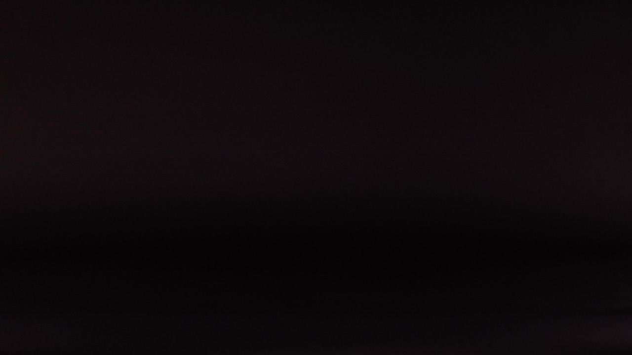 una pelota de cricket moviéndose a través de un fondo oscuro