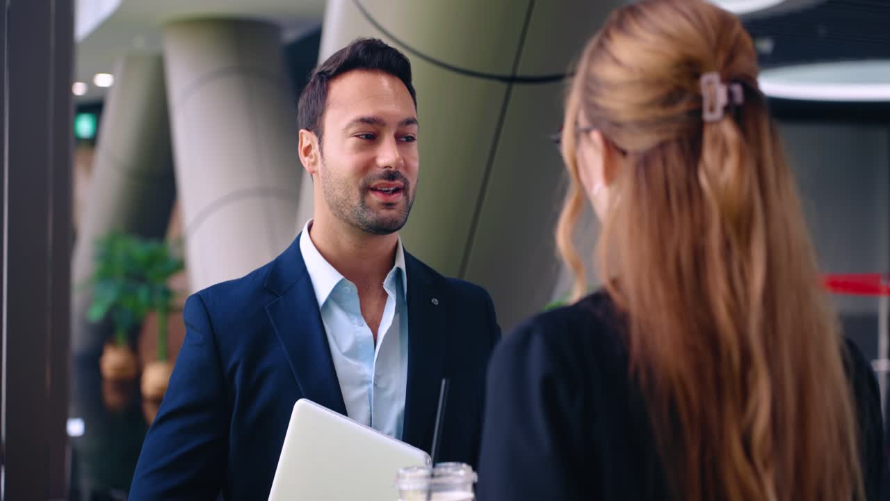 Business partners having casual discussion in office lobby, medium upper body focus on man