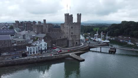 ancient caernarfon castle welsh harbour town aerial view medieval waterfront landmark slow descend