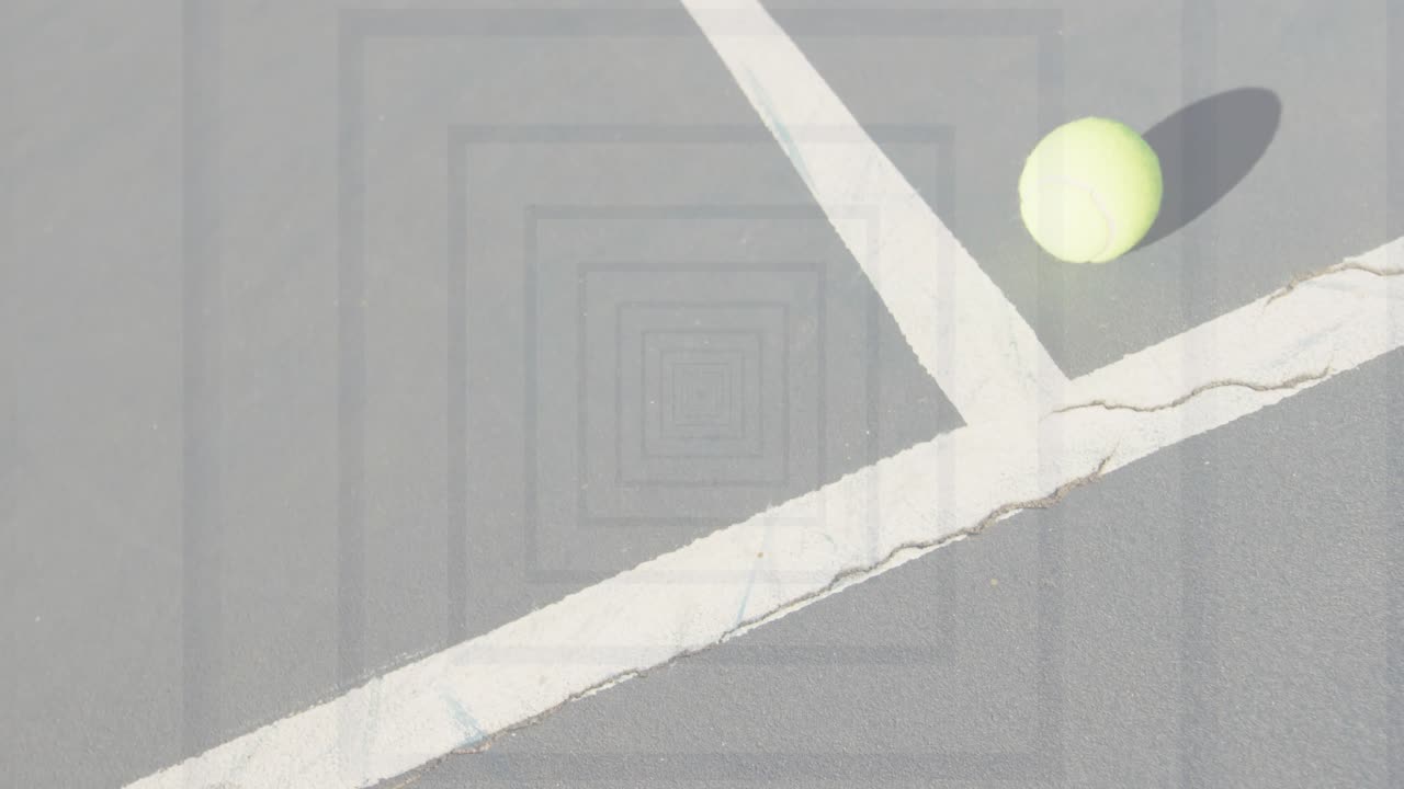 Yellow tennis ball lying on cracked textured gray court lines under bright sun casting sharp shadow