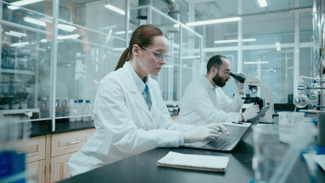 Cientista Mulher Digitanto em Laptop no Laboratório