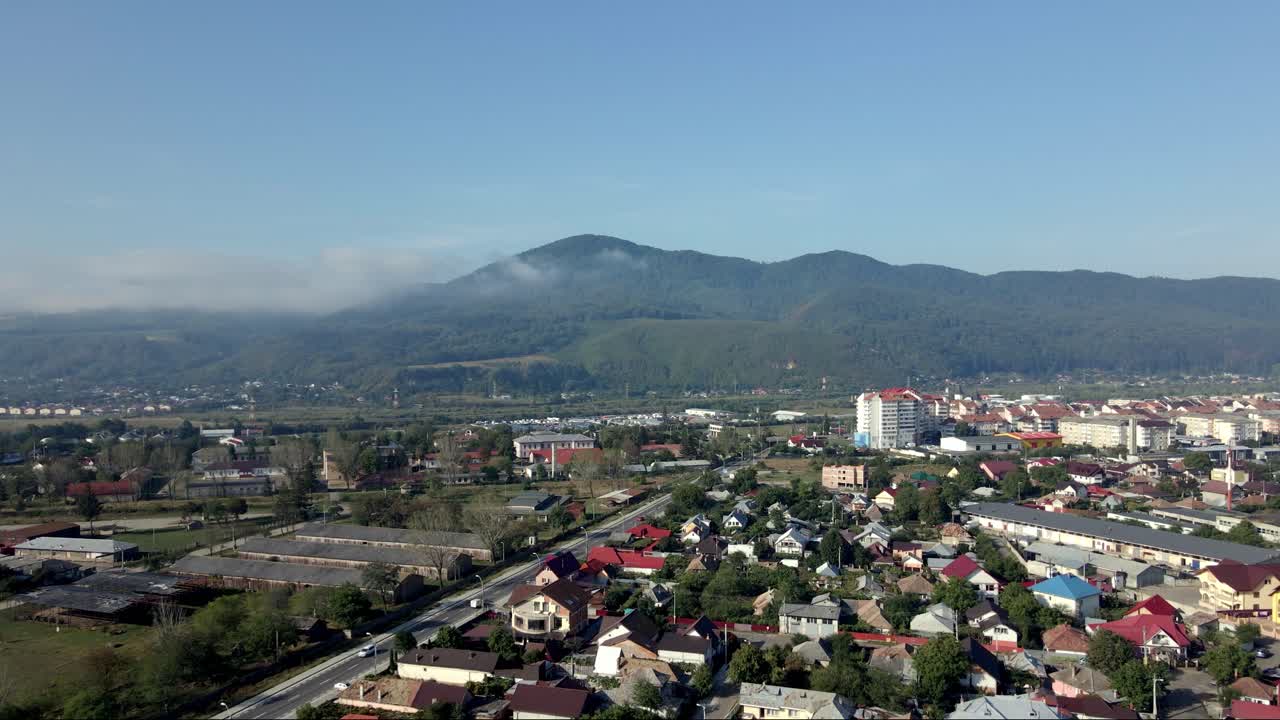 piatra neamț, moldavia occidental, rumania - un encantador paisaje urbano con las montañas de los cárpatos como telón de fondo durante la temporada de verano - avión no tripulado volando hacia adelante