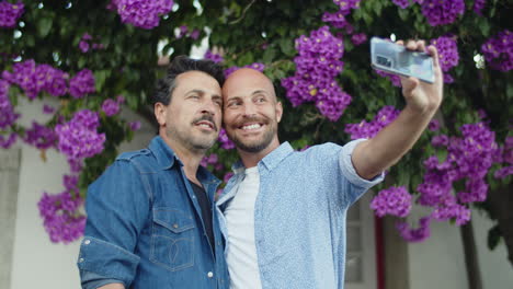 happy gay couple doing selfie on phone in park