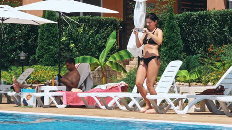 personas sentadas a la orilla de la piscina de un resort durante las vacaciones de verano