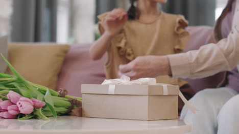 couple hugging with a gift and tulips on the table