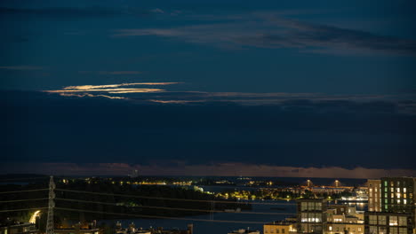 Moon-appearing-behind-clouds-on-the-Gulf-of-Finland,-night-in-Helsinki---Time-lapse