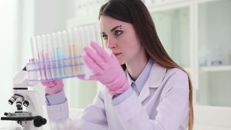 female scientist examining test tubes in a laboratory