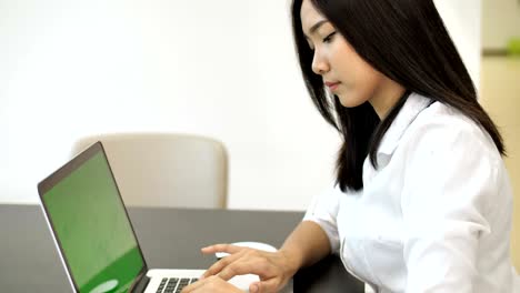 4k : happy asian business woman typing on a laptop computer with a key green screen
