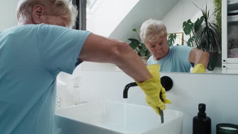 Mujer-Caucásica-Mayor-Limpiando-El-Lavabo-Del-Baño