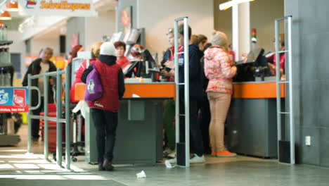 people entering the supermarket other customers paying or waiting