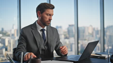 serious professional using smartphone in modern office. company leader typing