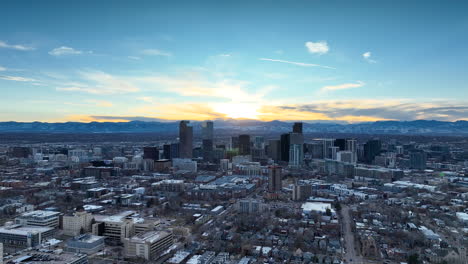 Winter-aerial-pullback-view-of-Denver-skyline-during-vibrant-sunset