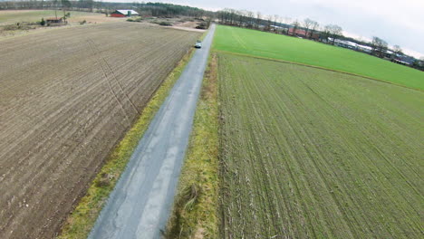 Flug-Von-Oben-Nach-Unten,-Der-Die-Straße-Zwischen-Landwirtschaftlichen-Und-Ländlichen-Feldern-Im-Freien-In-Der-Natur-Zeigt