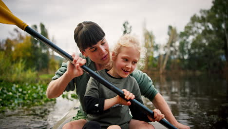 mother, girl and rowing kayak in river on holiday