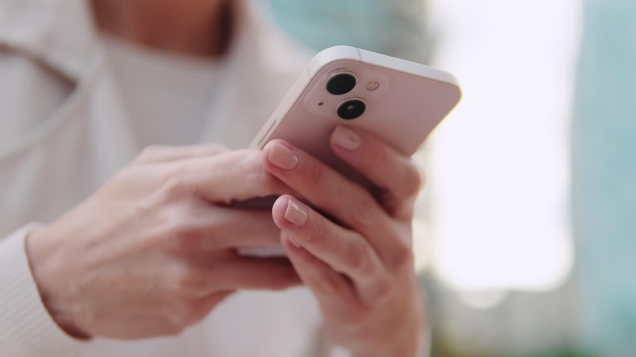 Close-up of hands typing and scrolling on a smartphone