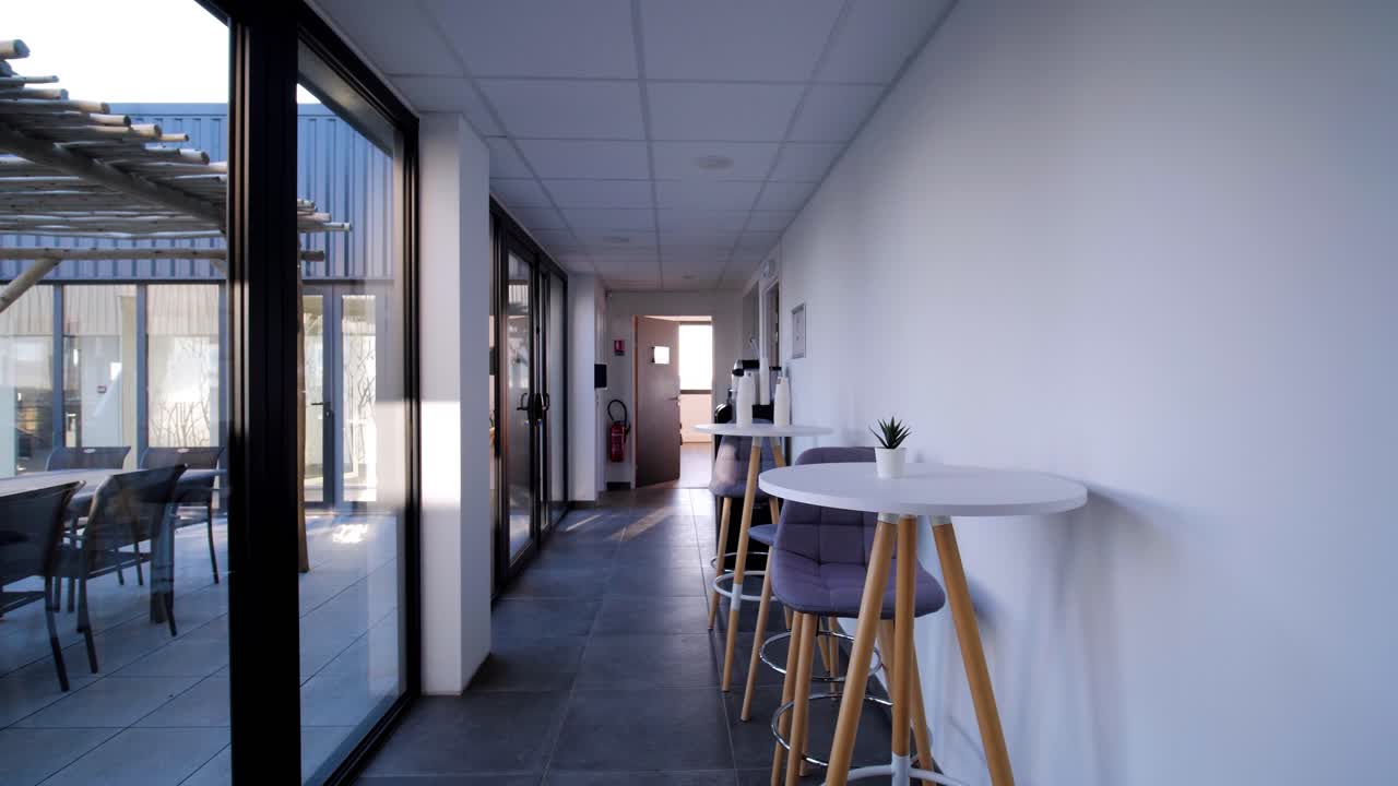 un muñeco lento disparado a lo largo de mesas con sillas colocadas junto a una pared en un pasillo