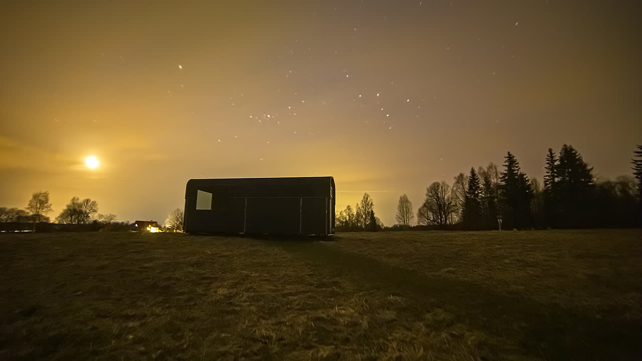 5k 시간의 날아다니는 별, 보름달을 비추고 밤하늘에 떠오르는 클라우드스케이프 - 자정 동안 하늘의 오로라 보레알리스 불빛으로 색이 바뀝니다.