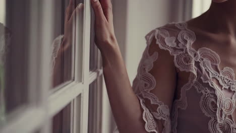 woman in a lace dress by a window