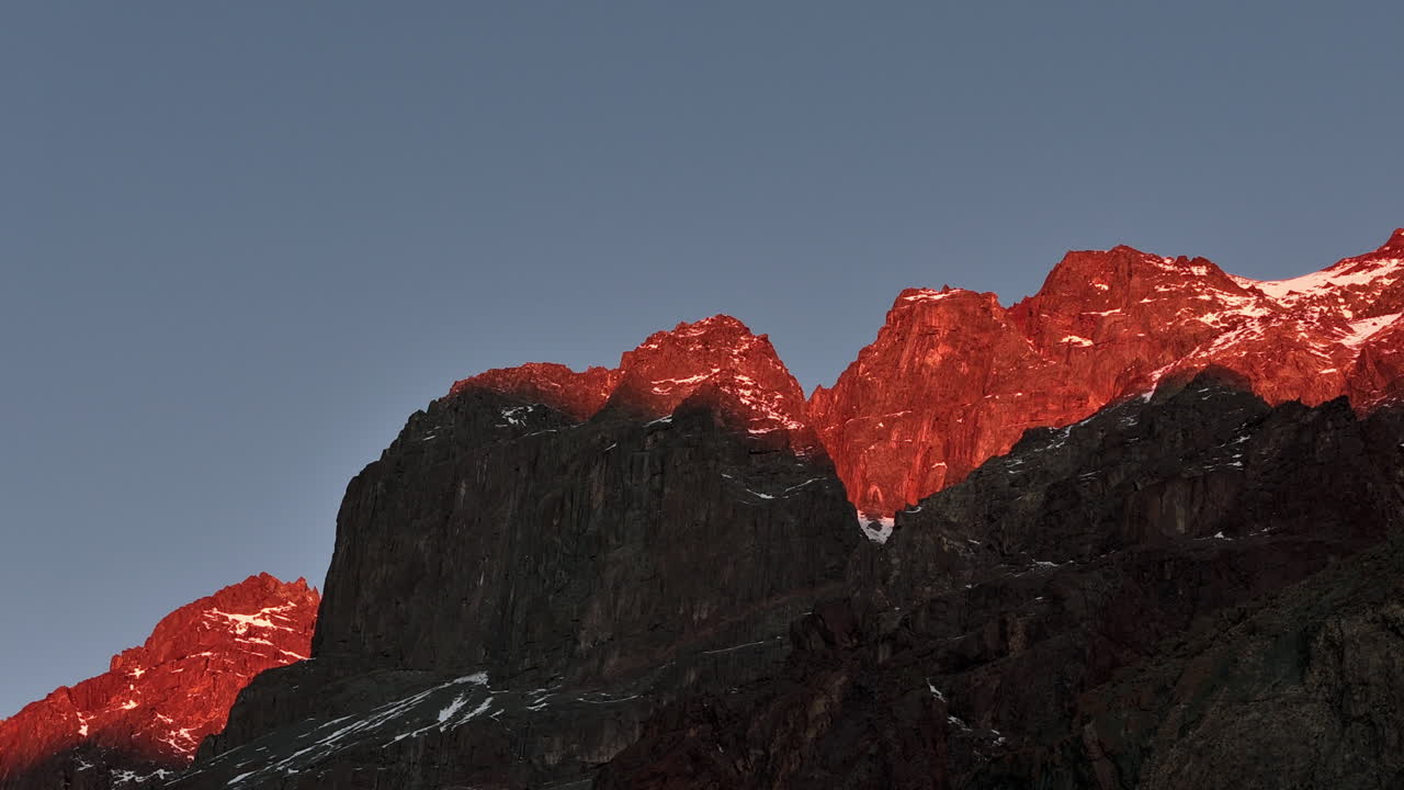 Hyperlapse showing the Andes mountains during sunset, with golden light illuminating rocky peaks and dramatic shadows across the slopes