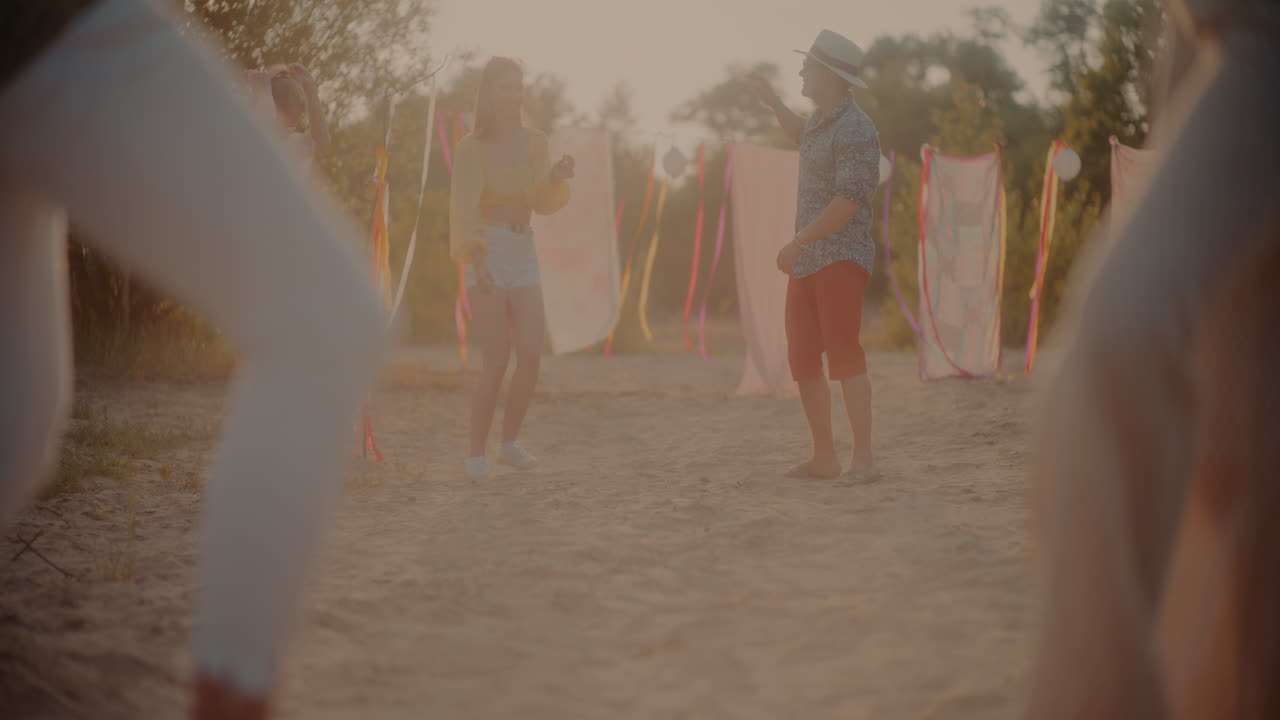 친구 들 이 해변 에서 함께 춤 을 추고 있다