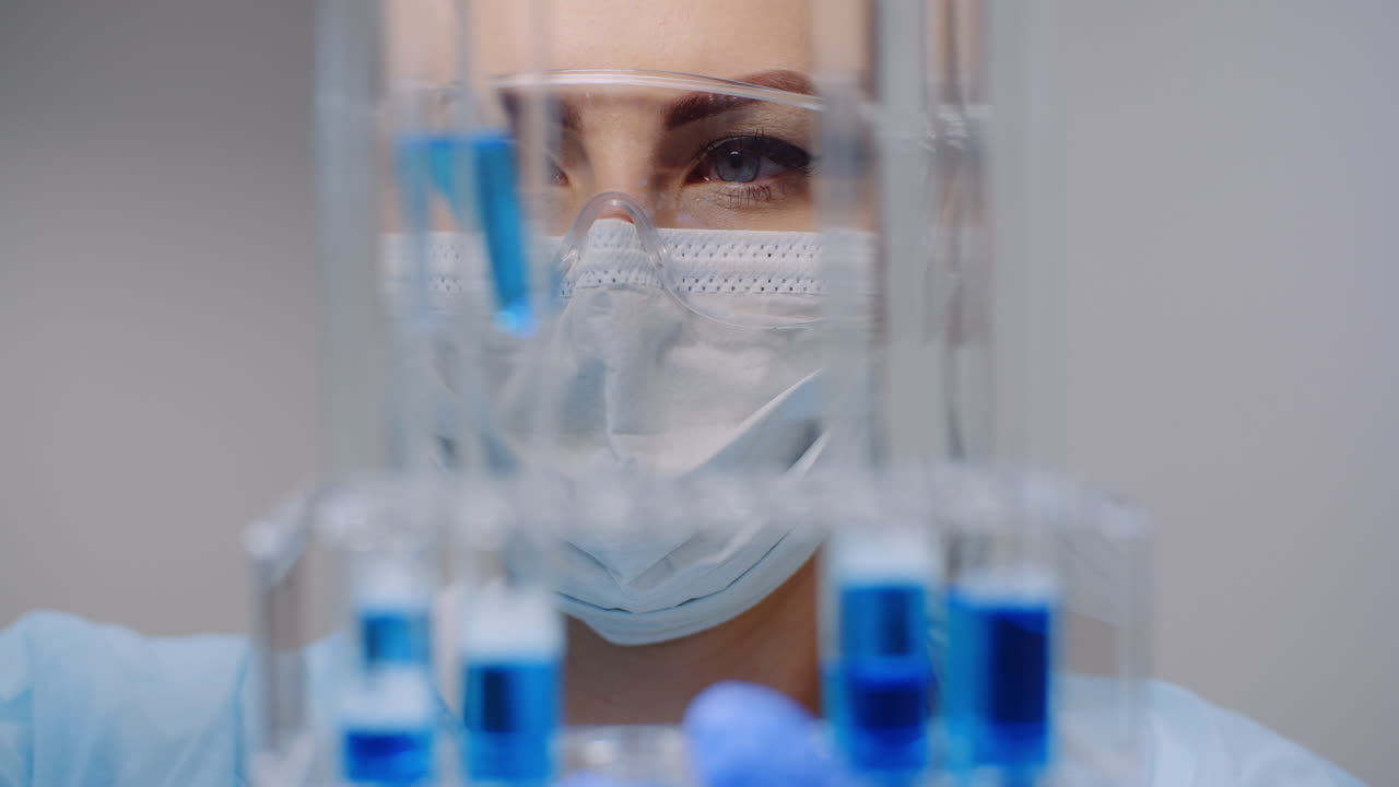 의사는 실험실 2에서 dna 분석을 위해 피펫에서 샘플 유리관으로 약을 조심스럽게 떨어뜨립니다.