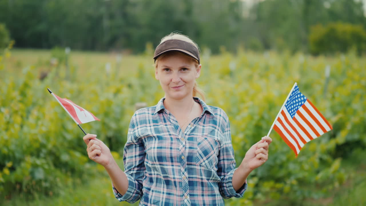 한쪽에는 미국 국기를, 다른 한쪽에는 캐나다 국기를 들고 있는 젊은 여성 농부