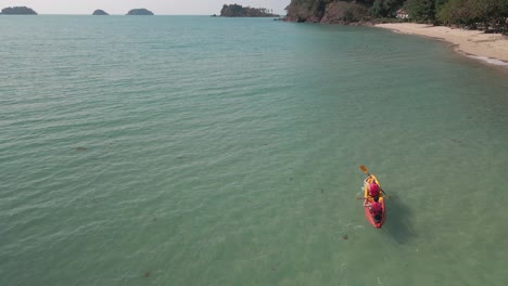 Vista-Aérea-De-Drones-En-Cámara-Lenta-De-Personas-En-Kayak-Cerca-De-Una-Playa-Tropical-Con-Islas-En-La-Distancia