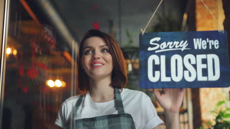 Cafe Employee with Open and Closed Signs