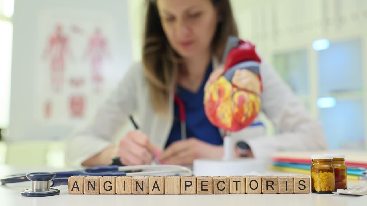 Blocchi di legno formano le parole angina pectoris vicino a un modello di cuore