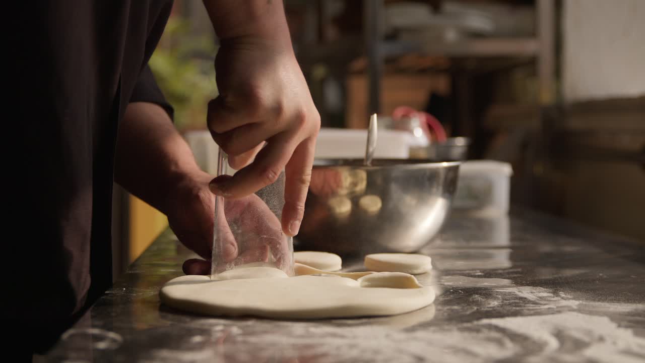 Small and cozy bakery, chef making pie from flattened dough, hands in closeup