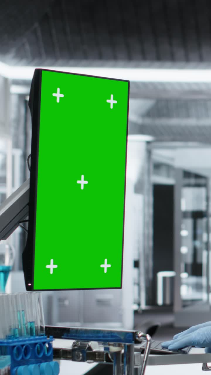 Vertical Video Vertical green screen monitor next to black medic in hazmat suit