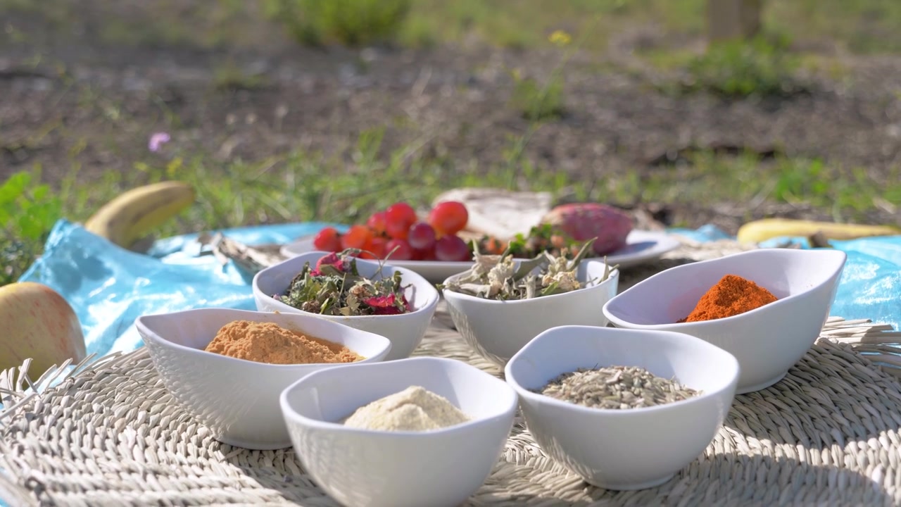 Pan shot og herbs and spices on a picnic mat outdoors