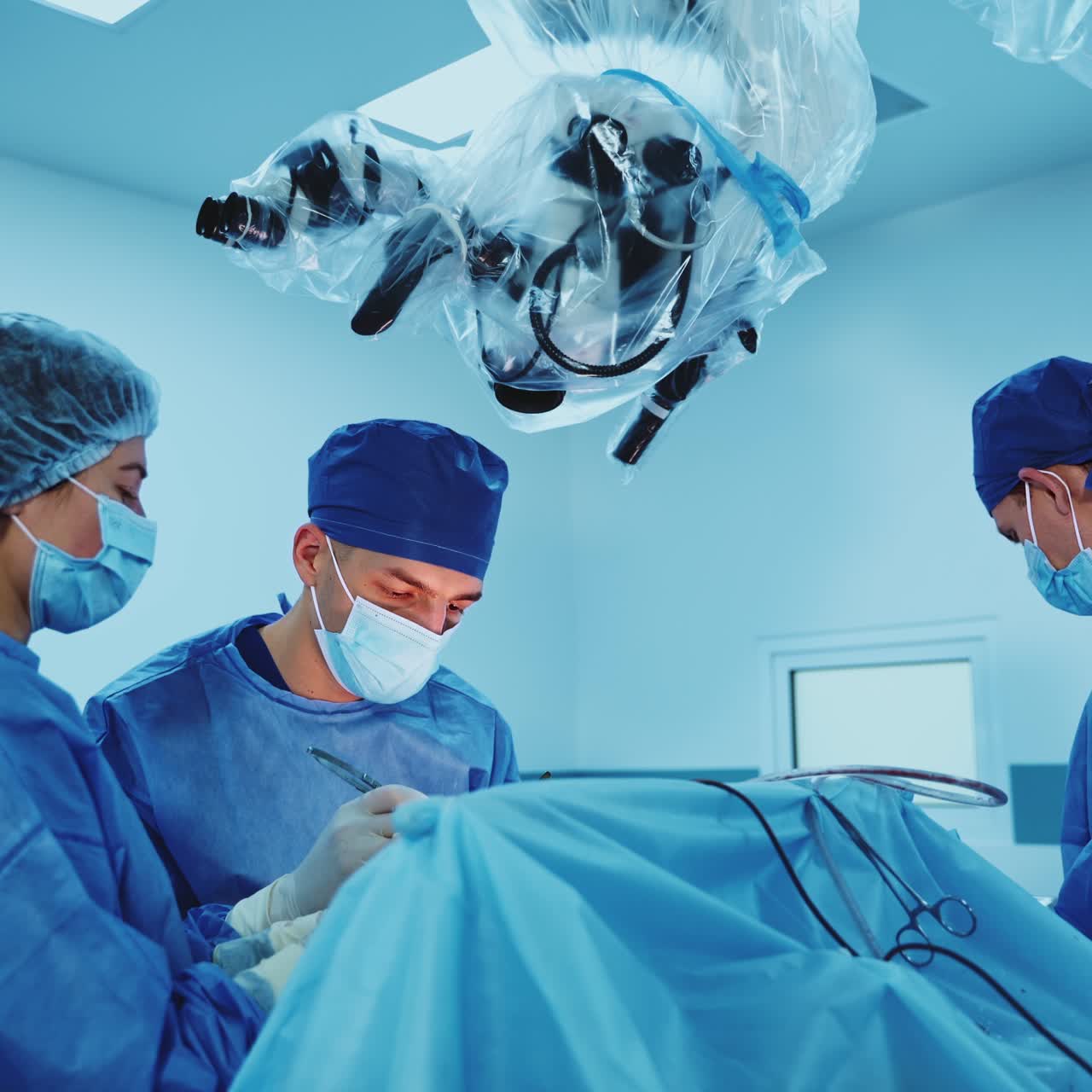 Neurosurgeon performs operation assisted by two medics. Surgery procedure in the modern hospital