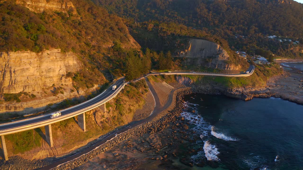 호주 뉴 사우스 웨일즈에서 일몰 동안 그랜드 퍼시픽 드라이브를 따라 해안 바다 절벽 다리