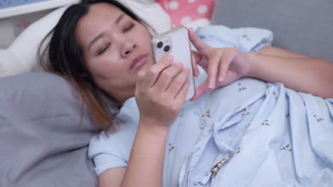 young pregnant asian woman spending her time on social media