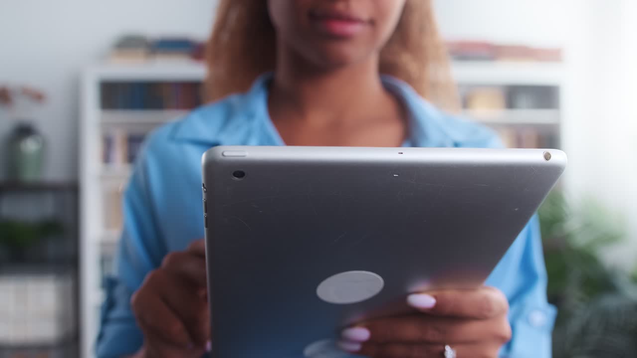 closeup tableta electrónica en las manos mujer afroamericana estudiante en camisa azul
