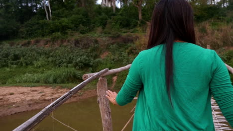 woman walking on a wooden bridge in a rural setting