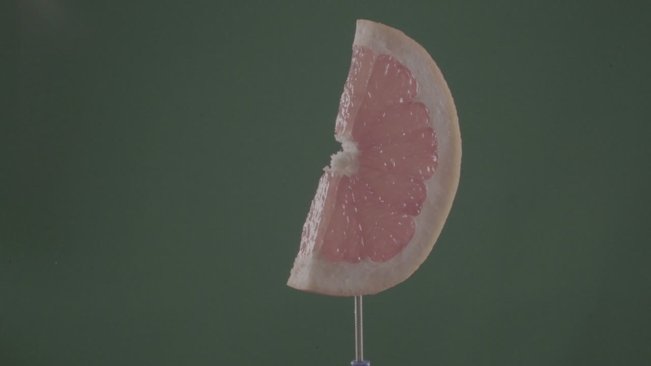 Pompelmo in rotazione continua su schermo verde per chroma key.