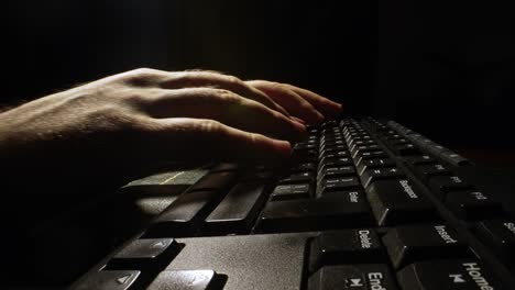 man is typing on a keyboard.