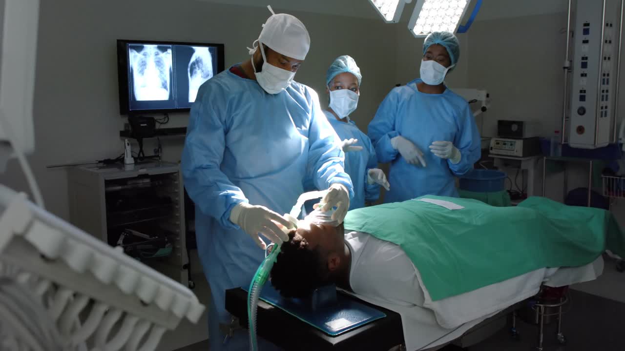 Diversi chirurghi somministrano l'anestesia a un paziente in sala operatoria, al rallentatore.