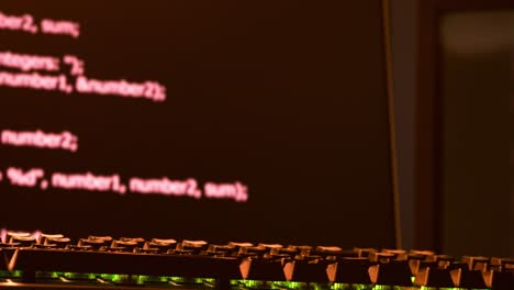 Die-Tastatur-Des-Hackers-Befindet-Sich-Im-Vordergrund,-Während-Im-Hintergrund-Code-über-Die-Bildschirme-Läuft