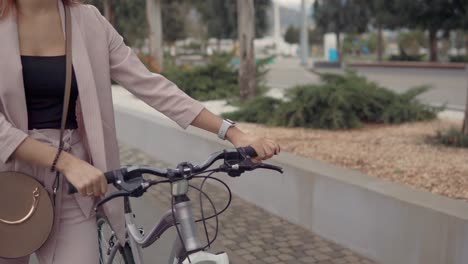 mujer caminando con una bicicleta en la ciudad